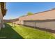 Grassy backyard with a well-maintained fence ensuring privacy and security, with extra hillside space at 10502 W Bronco Trl, Peoria, AZ 85383