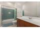 Modern bathroom with green tile accents, tub with shower, and a wooden vanity with white countertop at 10502 W Bronco Trl, Peoria, AZ 85383
