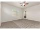 A bright room with neutral carpet, ceiling fan, and a door leading to outdoor space at 10502 W Bronco Trl, Peoria, AZ 85383