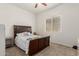 Neutral bedroom with cozy carpet and a dark wood headboard; bright natural light through window at 10502 W Bronco Trl, Peoria, AZ 85383