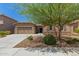 Charming single-story home with a two-car garage, desert landscaping, and a stone accent wall at 10502 W Bronco Trl, Peoria, AZ 85383