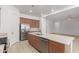 A modern kitchen with wooden cabinets and stainless steel appliances open to living space at 10502 W Bronco Trl, Peoria, AZ 85383
