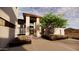 Modern home entrance with stone columns, landscape design, and vibrant purple flowers at 10772 E Canyon Cross Way, Scottsdale, AZ 85255