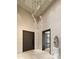 Elegant foyer featuring a modern chandelier, sleek doorway, and decorative sculpture at 10772 E Canyon Cross Way, Scottsdale, AZ 85255