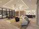 Stylish living room with a large sectional sofa, bar area, and a view of the home gym and car collection at 10772 E Canyon Cross Way, Scottsdale, AZ 85255