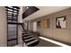 Modern staircase with open treads, accent wall art, and a large window providing natural light at 10772 E Canyon Cross Way, Scottsdale, AZ 85255