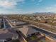 Aerial view of the home, showcasing the backyard putting green and the surrounding community with mountain views at 11019 E Tiburon Ave, Mesa, AZ 85212