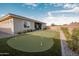 Backyard with an artificial putting green, lush plants, and low-maintenance landscaping at 11019 E Tiburon Ave, Mesa, AZ 85212