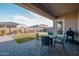 View of the outdoor dining table and putting green from under the covered patio at 11019 E Tiburon Ave, Mesa, AZ 85212