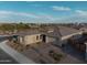 View of the front exterior featuring a well-manicured yard, desert landscaping, and a three-car garage at 11019 E Tiburon Ave, Mesa, AZ 85212
