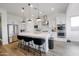 Modern kitchen featuring stainless steel appliances, white cabinets, a large island with seating and wood look tile floors at 11019 E Tiburon Ave, Mesa, AZ 85212