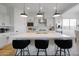 Modern kitchen boasts a large island, stylish pendant lighting, and sleek black counter stools for a chic design at 11019 E Tiburon Ave, Mesa, AZ 85212