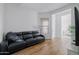Cozy living room featuring a black leather sofa, wood floors, and abundant natural light at 11019 E Tiburon Ave, Mesa, AZ 85212