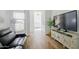 Inviting living room with a black leather sofa, TV, and stylish cabinet for storage at 11019 E Tiburon Ave, Mesa, AZ 85212