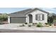 Charming single-story home featuring a gray roof, grey shutters, stucco walls, and a two-car garage at 14403 W Sand Hills Rd, Surprise, AZ 85387
