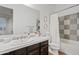 Well-lit bathroom featuring a dark vanity, tiled countertop and shower with decorative tile accents at 1500 E Sagittarius Pl, Chandler, AZ 85249
