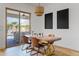 Bright dining area with modern chandelier, wooden table, and sliding glass doors leading to the patio and pool at 1500 E Sagittarius Pl, Chandler, AZ 85249