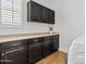 Functional laundry room with wooden cabinets, light countertop, and a front-load washing machine at 1500 E Sagittarius Pl, Chandler, AZ 85249