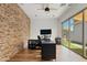 Bright home office with exposed brick, desk, ceiling fan and sliding glass doors to the back yard at 1500 E Sagittarius Pl, Chandler, AZ 85249