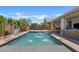 Backyard featuring a pool with water fountains, covered patio, and lush landscaping for outdoor enjoyment at 1500 E Sagittarius Pl, Chandler, AZ 85249