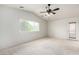 Bright bedroom with large window, neutral carpet, ceiling fan and access to the backyard at 1735 E Hope St, Mesa, AZ 85203