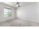 A bright bedroom featuring a ceiling fan, neutral carpet, and a window bringing in natural light at 1735 E Hope St, Mesa, AZ 85203