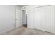A carpeted bedroom with a view into another room featuring wood flooring and closet space at 1735 E Hope St, Mesa, AZ 85203