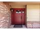 Stylish red front door with glass accents and classic hardware, framed by brick and siding at 1735 E Hope St, Mesa, AZ 85203