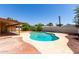 Backyard pool surrounded by patio and mulch with covered patio and partial fence view at 1735 E Hope St, Mesa, AZ 85203