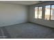 Neutral carpet and wall colors add a sense of spaciousness to the bedroom at 18001 W Lupine Ave, Goodyear, AZ 85338