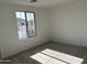 The carpeted room is well-lit by the window offering neighborhood views at 18001 W Lupine Ave, Goodyear, AZ 85338