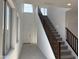 Bright entryway featuring high ceilings, staircase with wood railing, and tile flooring at 18001 W Lupine Ave, Goodyear, AZ 85338