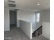 Upstairs loft area with neutral carpet, and a staircase with dark wood railing at 18001 W Lupine Ave, Goodyear, AZ 85338