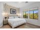 Bright bedroom features a patterned accent wall, two windows, and wood floors at 18127 N 98Th Way, Scottsdale, AZ 85255