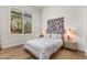 Bedroom with a queen bed, wood floors, and a window with plantation shutters at 18127 N 98Th Way, Scottsdale, AZ 85255