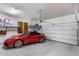 Spacious garage with a red sportscar, overhead storage racks, and an automatic door at 18127 N 98Th Way, Scottsdale, AZ 85255