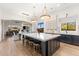 Modern kitchen features a large island with seating, pendant lighting, and views into the dining room and living room at 18127 N 98Th Way, Scottsdale, AZ 85255