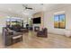 Bright living room features a fireplace, ceiling fan, and natural light from the windows at 18127 N 98Th Way, Scottsdale, AZ 85255