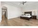 Spacious main bedroom featuring hardwood floors, a tray ceiling, and an elegant dark wood bed set at 18127 N 98Th Way, Scottsdale, AZ 85255