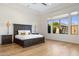 Large, bright main bedroom suite with a dark wood bed set and scenic views from the large windows at 18127 N 98Th Way, Scottsdale, AZ 85255