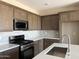 Well-lit kitchen featuring new appliances, granite countertops and a stylish tile backsplash at 18162 W Larkspur Dr, Goodyear, AZ 85338