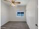 Carpeted bedroom with a ceiling fan, closet, and window offering natural light at 19707 N Pepka Ct, Maricopa, AZ 85138
