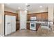 Bright kitchen with tile flooring, granite countertops, stainless sink, white appliances and wood cabinets at 2036 E Carob Dr, Chandler, AZ 85286