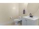 Bathroom featuring a toilet, vanity with a white cabinet, and a round mirror at 25218 W Carson Ct, Buckeye, AZ 85326