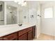 Bathroom featuring a vanity with wood cabinets, a large mirror, and a shower in the background at 25218 W Carson Ct, Buckeye, AZ 85326