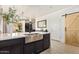Kitchen island featuring a stainless steel sink, modern faucet, and barstool seating at 25218 W Carson Ct, Buckeye, AZ 85326