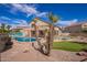 Stunning backyard oasis with pool, putting green, mural, outdoor bar, and desert landscaping perfect for entertaining at 2602 E Glass Ln, Phoenix, AZ 85042