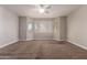 Spacious carpeted bedroom featuring bright natural light through multiple windows and a ceiling fan at 2602 E Glass Ln, Phoenix, AZ 85042