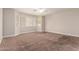 Spacious carpeted bedroom featuring bright natural light through multiple windows and a ceiling fan at 2602 E Glass Ln, Phoenix, AZ 85042