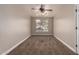 Neutral-toned bedroom featuring plush carpeting, a ceiling fan, and a view to the green outdoors at 2602 E Glass Ln, Phoenix, AZ 85042
